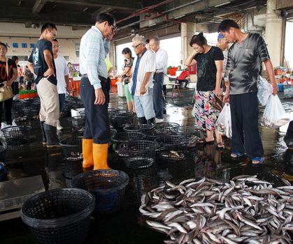 SINDA, TAIWAN -- SEPTEMBER 3: Potential buyers inspect fish at the daily fish auction at Sinda Port in southern Taiwan, on September 3, 2013 in Sinda.