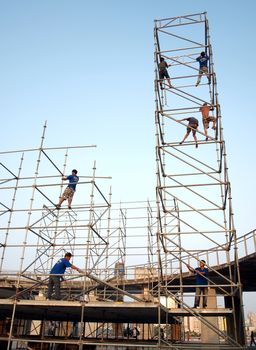 KAOHSIUNG, TAIWAN -- OCTOBER 21: Workers without safety harnesses high up on a scaffold erect a stage for an outdoor concert on October 21, 2012 in Kaohsiung.