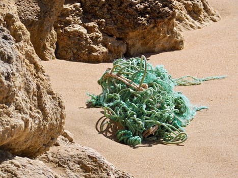 Green ropes on a sandy beach with cliffs
