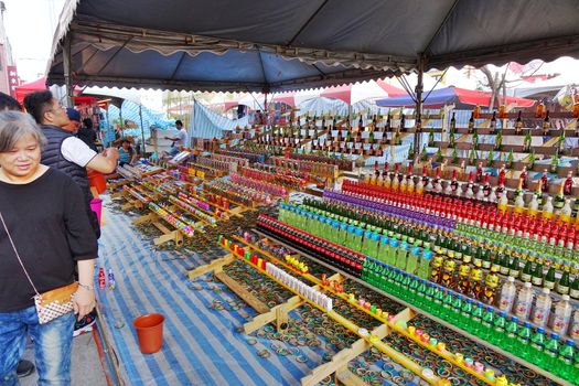 KAOHSIUNG, TAIWAN -- FEBRUARY 6, 2019: People try to throw bamboo rings over bottles in a skill game at a Chinese New Year Market.
