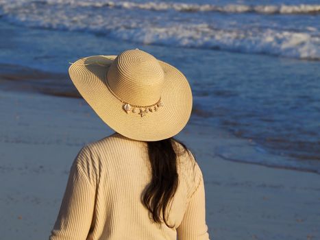 Lady woman with a hat at the ocean