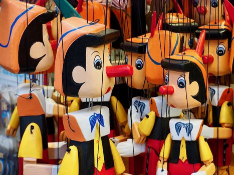 Macro of Pinocchio puppets hanging on strings