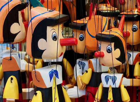 Macro of Pinocchio puppets hanging on strings