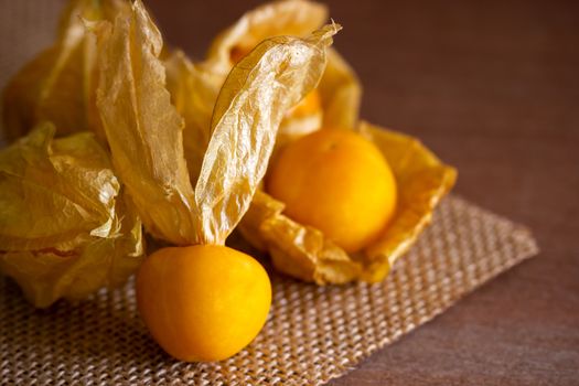 Closeup cape gooseberry on wooden table. Concept of health care or herb.