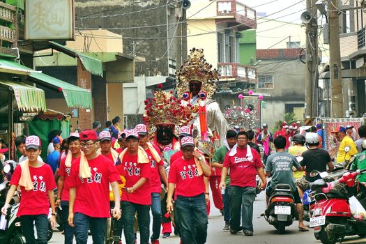 LINYUAN, TAIWAN -- MAY 28, 2017: Member of a religious temple carry effigies of deities through the narrow streets.
