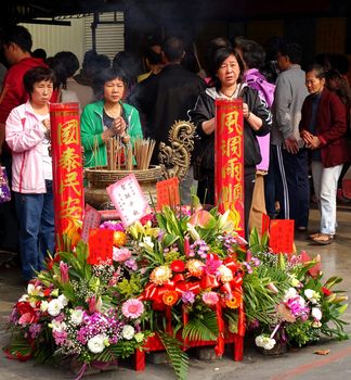 KAOHSIUNG, TAIWAN -- MARCH 2, 2014: Unidentified worshipers burn incense and say prayers at a ceremony at the Fu De Temple in Kaohsiung City.