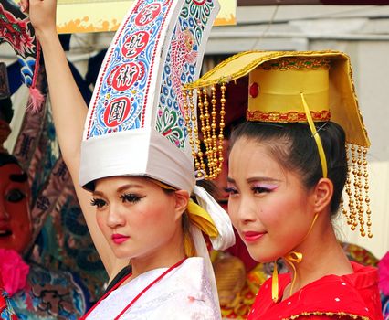 KAOHSIUNG, TAIWAN -- AUGUST 15, 2015: Two beautiful female dancers with elaborate headdress perform at the outdoor Third Prince temple carnival.