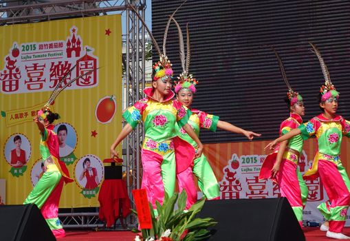 LUJHU, TAIWAN -- DECEMBER 12, 2015: Children dressed up in colorful costumes perform a traditional Chinese dance at the 2015 Lujhu Tomato Festival.