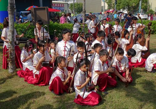 LUJHU, TAIWAN -- DECEMBER 12, 2015: A children's orchestra for traditional Chinese music waits for their performance at the 2015 Lujhu Tomato Festival.
