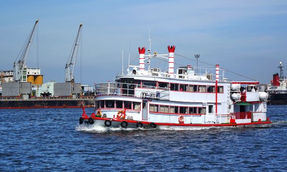 KAOHSIUNG, TAIWAN -- MAY 26, 2018: A tourism sightseeing boat passes through the Kaohsiung container port.
