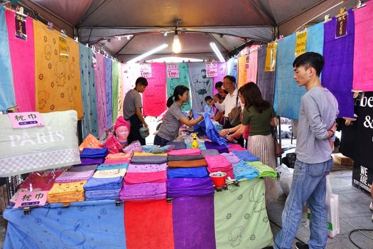 KAOHSIUNG, TAIWAN -- FEBRUARY 6, 2019: An outdoor market stall sells bath towels in various colors and sizes.