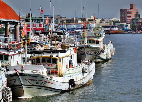 KAOHSIUNG, TAIWAN -- JUNE 27, 2019: Traditional Chinese fishing boats are anchored at the Gushan Ferry Pier.
