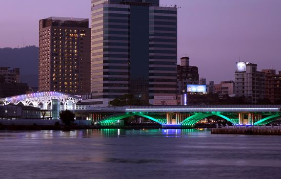 KAOHSIUNG, TAIWAN -- DECEMBER 1, 2018: Evening view of the Love River with the illuminated light rail bridge and the True Love Pier station.

