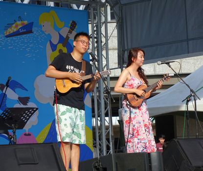 KAOHSIUNG, TAIWAN -- APRIL 23, 2016: Two unidentified musicians perform at the 1st Pacific Rim Ukulele Festival, a free public outdoor event.