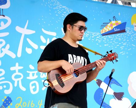 KAOHSIUNG, TAIWAN -- APRIL 23, 2016: An unidentified musician plays the bass at the 1st Pacific Rim Ukulele Festival, a free outdoor event.