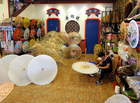 KAOHSIUNG, TAIWAN -- JULY 24, 2016: A female craftsperson makes oil-paper umbrellas, which is a traditional art and craft product by the Chinese Hakka people.