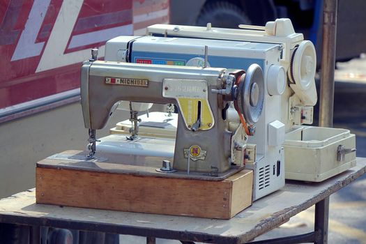 KAOHSIUNG, TAIWAN -- APRIL 5, 2015: An outdoor vendor sells second-hand sewing machines at a local market.