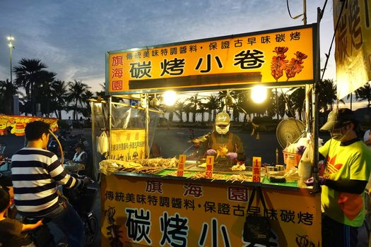 KAOHSIUNG, TAIWAN -- DECEMBER 22, 2018: A street vendor cooks grilled squid near the beach on Cijin Island.