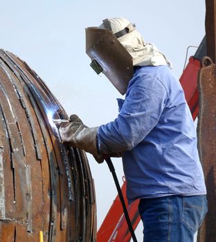 KAOHSIUNG, TAIWAN -- JANUARY 1, 2015: An unidentified welder works on an object for the Kaohsiung Iron and Steel Sculpture Festival.