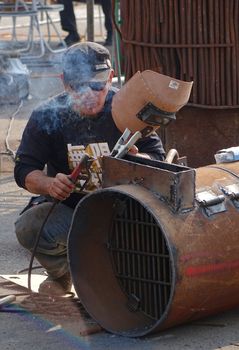 KAOHSIUNG, TAIWAN -- JANUARY 1, 2015: An unidentified welder works on an object for the Kaohsiung Iron and Steel Sculpture Festival.