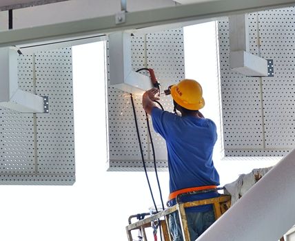 KAOHSIUNG, TAIWAN -- AUGUST 7, 2017: A worker with a helmet performs welding operations without adequate safety equipment.
