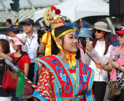 KAOHSIUNG, TAIWAN -- OCTOBER 1, 2017: A young woman dressed in a festive native costume joins the parade at the opening of the 2017 Ecomobility Festival. 