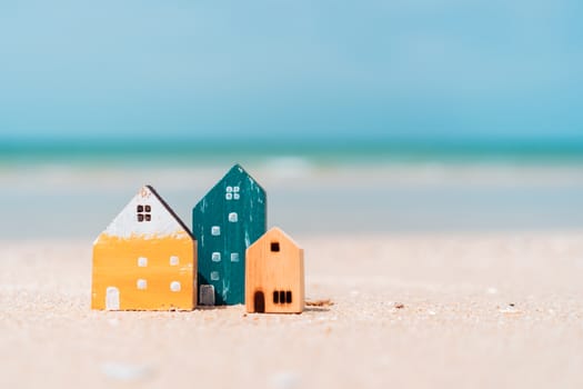 Model of a little house on sand with nature beach background. Dream life concept.