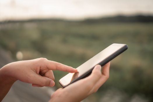 Woman hand use smartphone to do work business, social network, communication in public nature space.