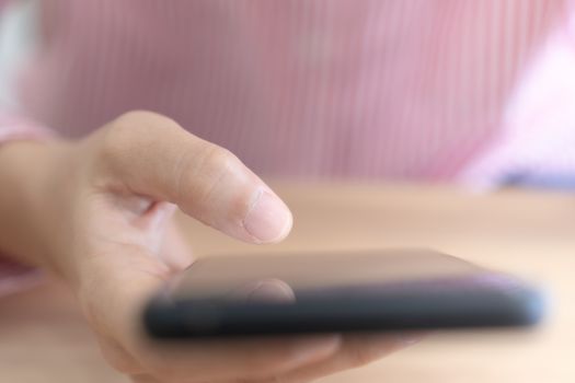 Woman hand use smartphone to do work business, social network, communication in public space.