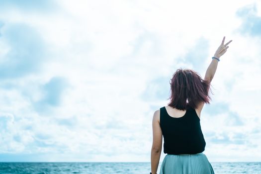 Woman rise hands up to sky freedom concept with sunset sky and summer beach season background.