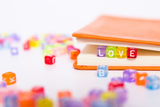 LOVE word on colorful bead block as bookmark in book. love and romantic fiction, happy valentine's day greeting card and gift