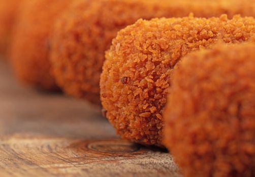 Brown crusty dutch kroketten on a serving tray, selective focus, isolated