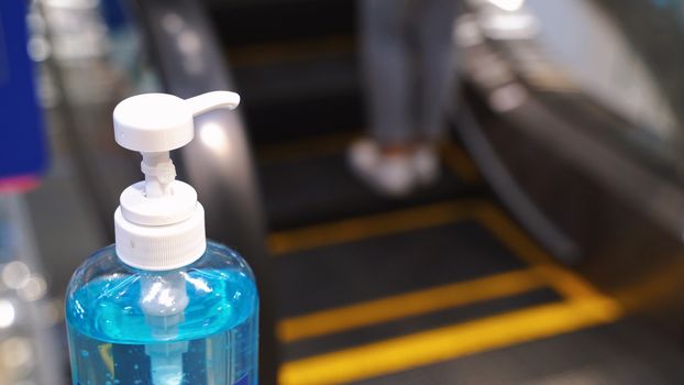 Close up alcohol gel sanitizer at the escalator for prevent the spread of pandemic Covid-19 and Coronavirus, healthcare and hygiene concept
