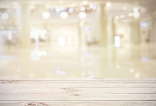 Empty wooden board table top on blur abstract of shopping mall background, for montage product or display, mock up for display of product