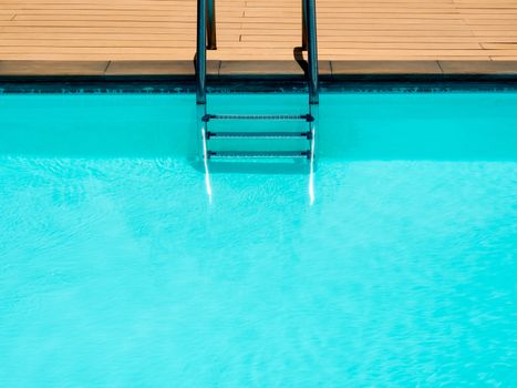Outdoor swimming pool background minimal style. Top view of grab bars ladder in the blue swimming pool with copy space.