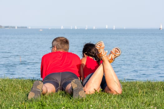 Joyful young couple is overlaping shore of the lake