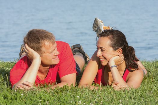 Joyful young couple is overlaping shore of the lake