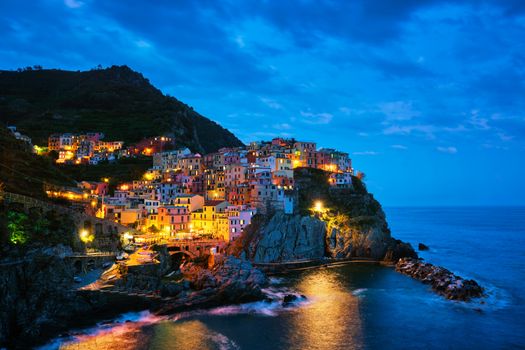 Manarola village popular european italian tourist destination in Cinque Terre National Park UNESCO World Heritage Site, Liguria, Italy illuminated in the evening