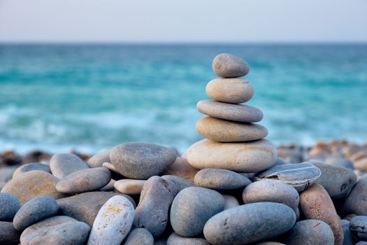 Zen meditation relaxation concept background - balanced stones stack close up on sea beach