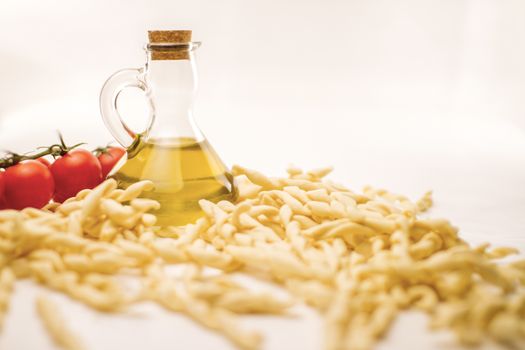 Close up still life of italian handmade pasta fusilli al ferretto with tomato puree and extra virgin olive oil on white background