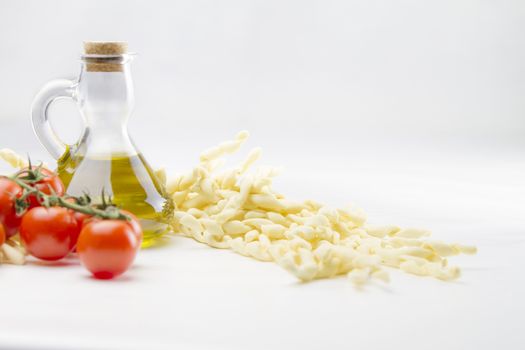 Close up still life of italian handmade pasta fusilli al ferretto with tomato puree and extra virgin olive oil on white background