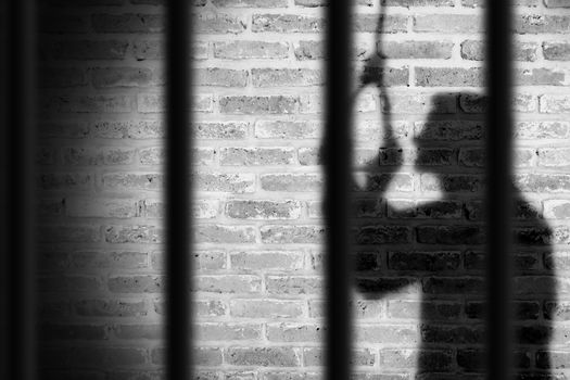shadow of prisoner man hanging suicide inside the jail. light and shadow