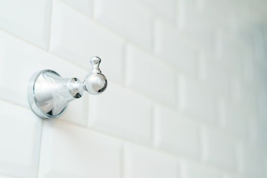 Towel metal hook on the white brick wall.