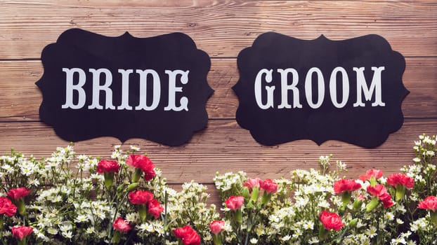 Bride and Groom text sign on wooden background decorated with flower, vintage style. wedding sign concept