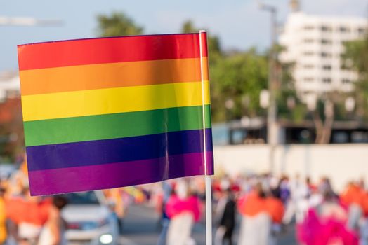 LGBT pride month background. a spectator waves a gay rainbow flag at LGBT gay pride parade festival in Thailand