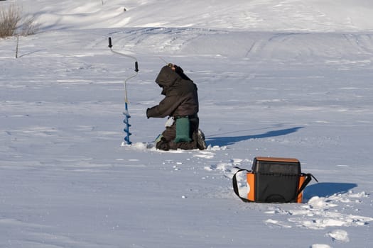 fishing in the winter on the ice on a sunny day