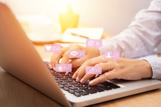 people using notebook computer laptop for social media interactions with notification icons from friend in social network with like, message, email, mention and star above smartphone screen. internet