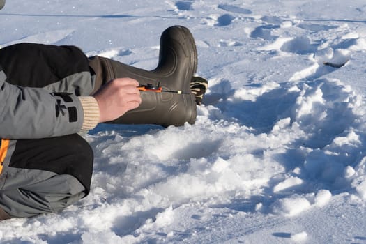 fishing in the winter on the ice on a sunny day