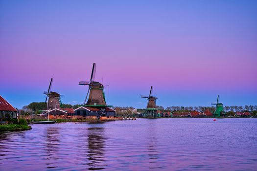 Windmills at famous tourist site Zaanse Schans in Holland in twilight after sunset. Zaandam, Netherlands