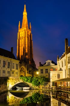 Church of Our Lady and canal illuminated in the night. Brugge Bruges, Belgium